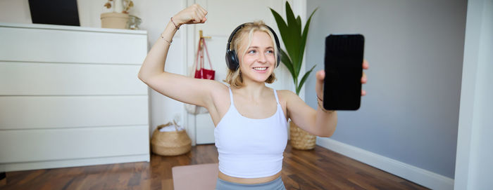 Portrait of young woman exercising at home