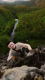 High angle view of rock climber wearing mask while climbing on mountain 