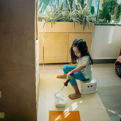 Little girl painting recycled cardboard at home.