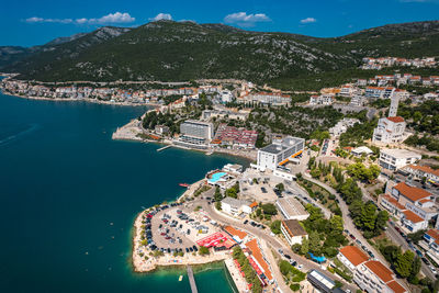 High angle view of city by sea against sky