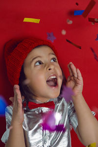 Christmas portrait of  boy child in silver shirt and red bow tie catches glitter confetti on holiday