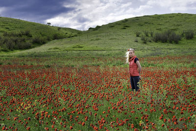 Full length of woman standing on field against sky