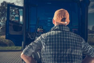 Rear view of man standing by truck