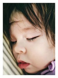 Close-up portrait of cute girl sleeping 