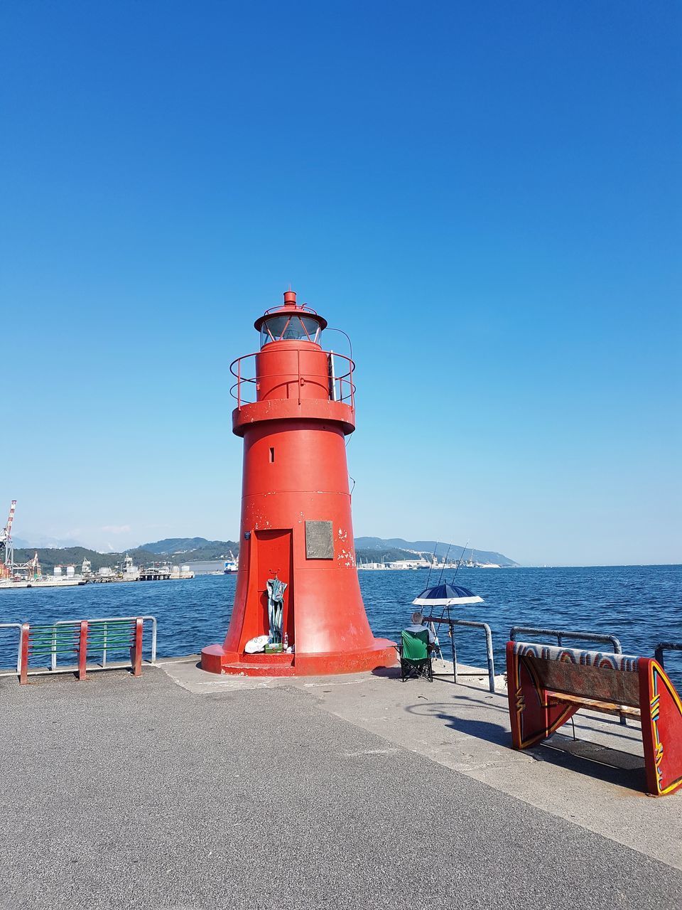 LIGHTHOUSE BY SEA AGAINST CLEAR SKY