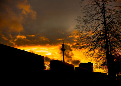 Low angle view of silhouette buildings against cloudy sky