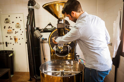 Barista preparing coffee in machinery at cafe