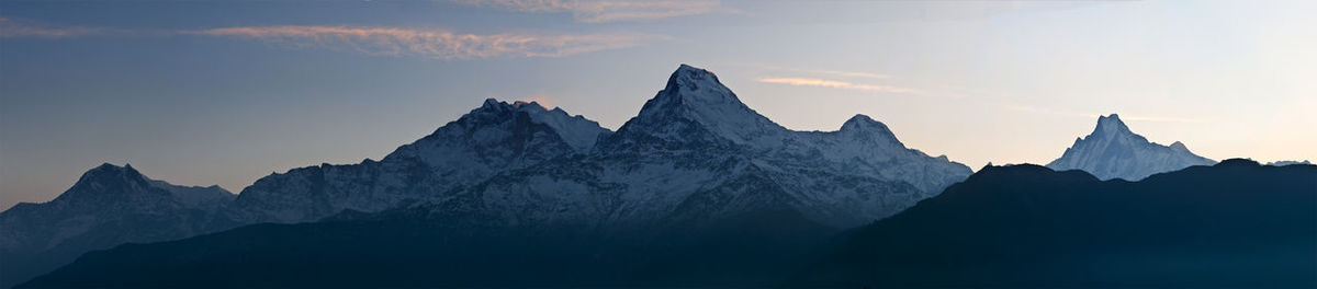 Panoramic shot of snow covered mountain against sky during sunset