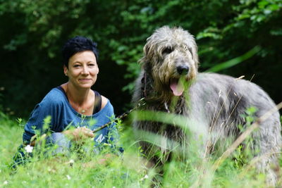 Woman with irish wolfhound dog on grassy field