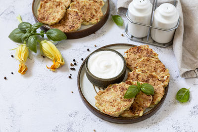 Zucchini fritters. vegetarian zucchini pancakes with cheese, served with sour cream