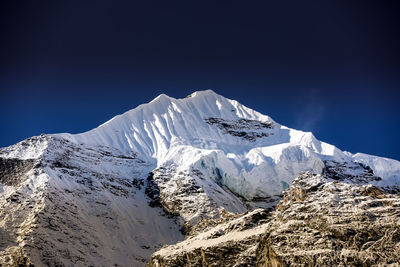 Scenic view of snowcapped mountains against clear blue sky