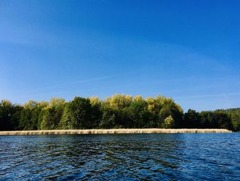 Scenic view of lake against clear blue sky