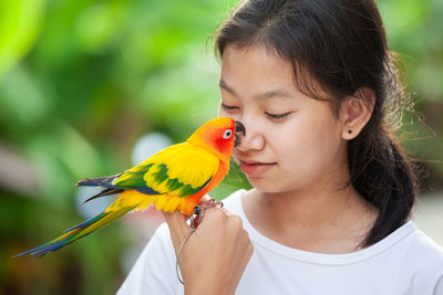 Close-up of girl holding bird
