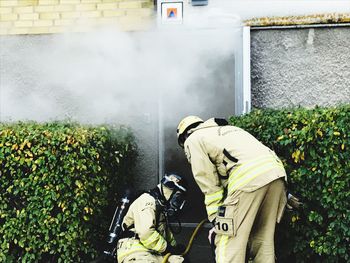 Firefighters wearing uniform while working by plants