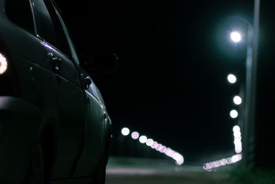 Low angle view of man standing against illuminated city at night