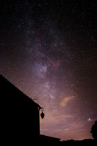 Low angle view of silhouette stars against sky at night