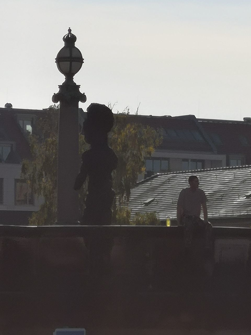 SILHOUETTE PEOPLE STANDING AGAINST BUILDING AGAINST CLEAR SKY