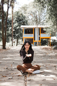 Portrait of smiling young woman sitting outdoors