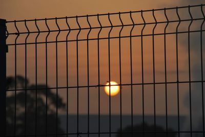 Fence against sky during sunset