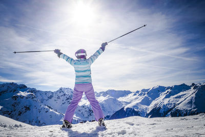 Woman skiing on snowy field during sunny day