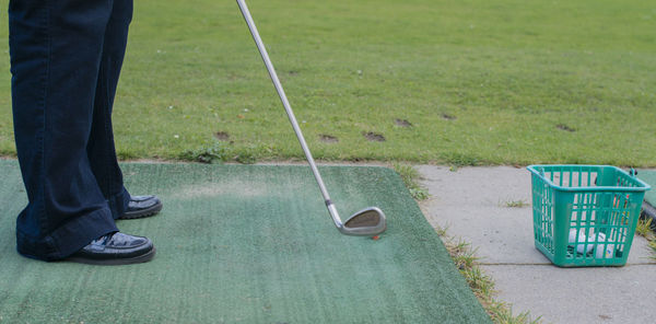 Low section of man standing on golf course