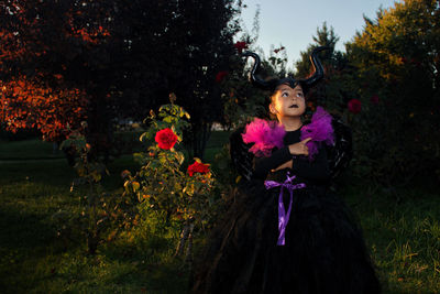 Girl with maleficent costume playing in the woods