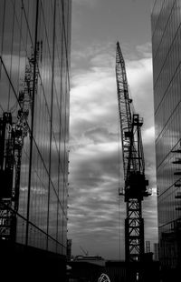 Low angle view of cranes against sky