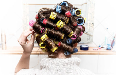 Rear view of woman with curlers in hair