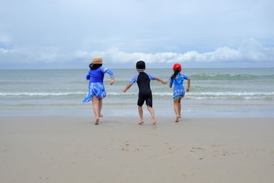 Happy children playing water on beach