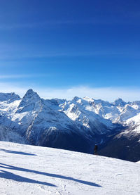 Scenic view of snowcapped mountains against blue sky
