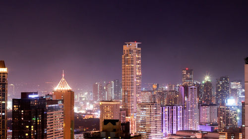 Illuminated buildings against sky at night