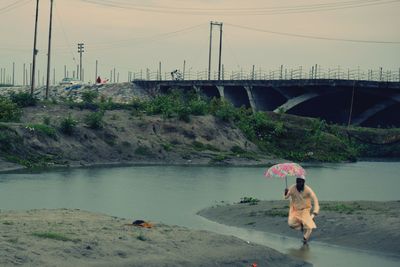 Rear view of two men walking on bridge