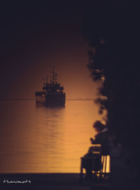 Silhouette of ship in sea against sky during sunset