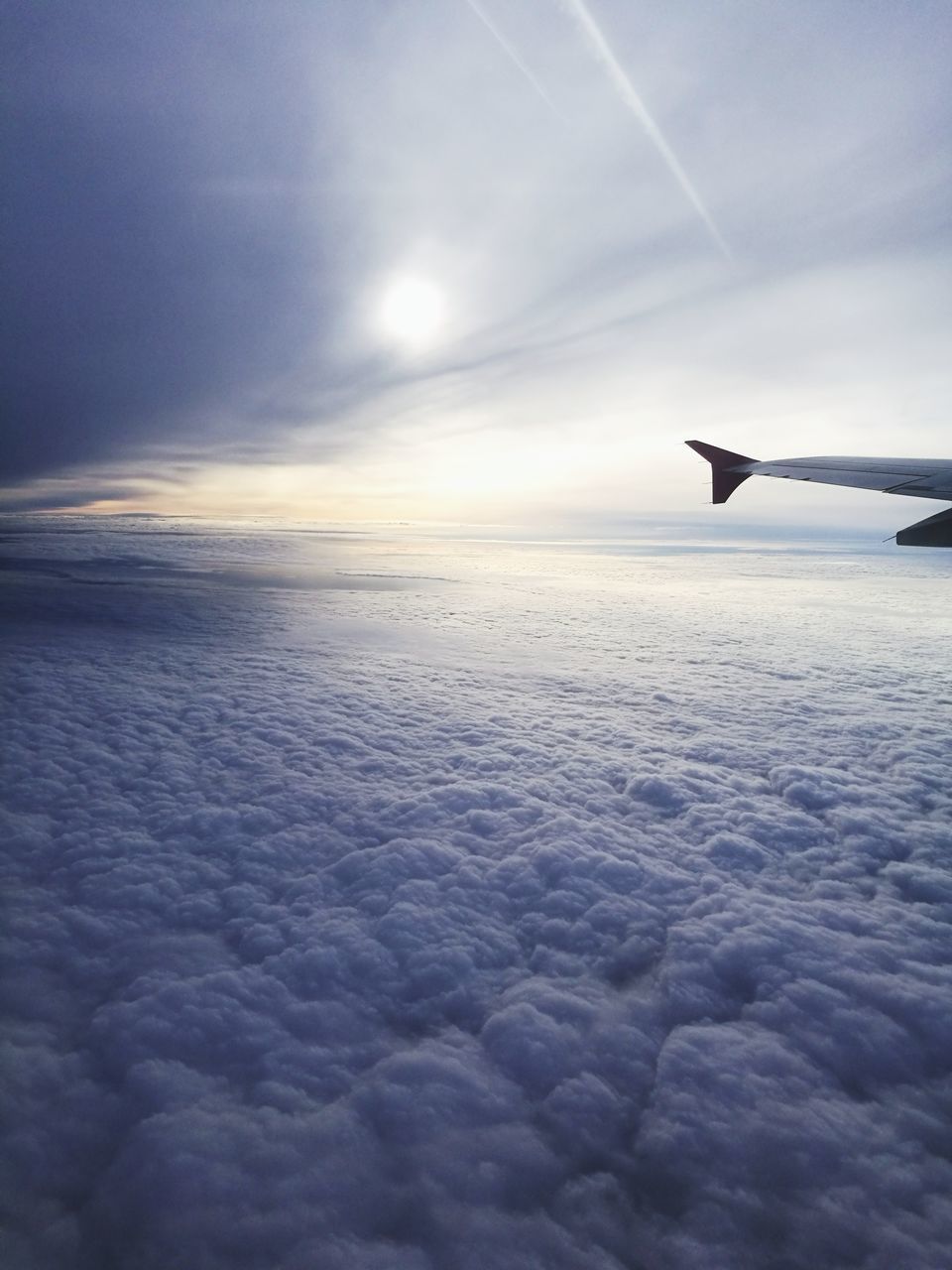 AIRPLANE WING OVER SEA AGAINST SKY