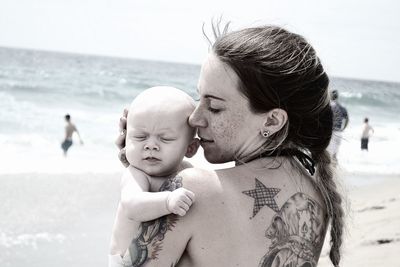 Mother and daughter standing at beach