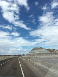 Empty road against cloudy sky