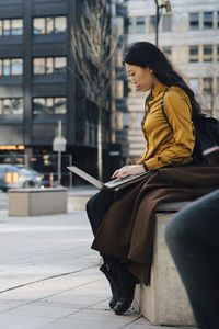 Woman working outside using laptop