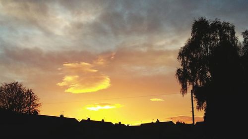 Low angle view of silhouette trees against dramatic sky