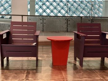 Empty chairs and table against window