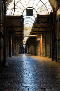 Rear view of woman walking on street amidst buildings in city