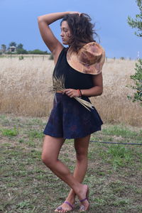 Midsection of woman standing on field against sky