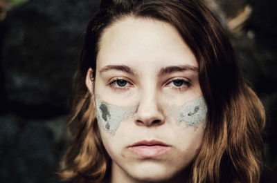 Portrait of young woman with mud pack