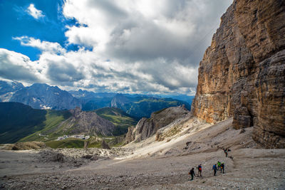 People walking on mountain against sky