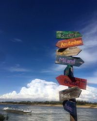 Information sign on beach against sky