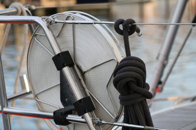 Close-up of ropes tied on railing of boat