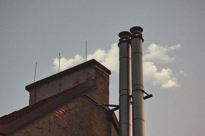 Low angle view of smoke stacks against sky