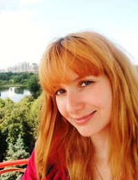 Portrait of smiling young woman against sky
