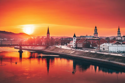 Reflection of buildings in city at sunset