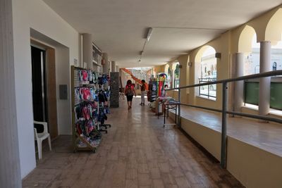 Rear view of people walking in corridor of building