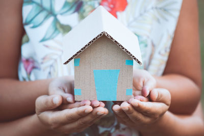 Close-up of people holding model home